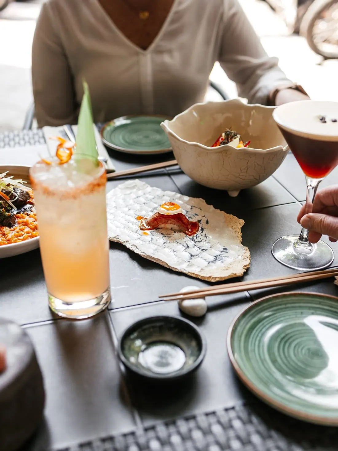 A guest at the table with cocktails and dishes to share