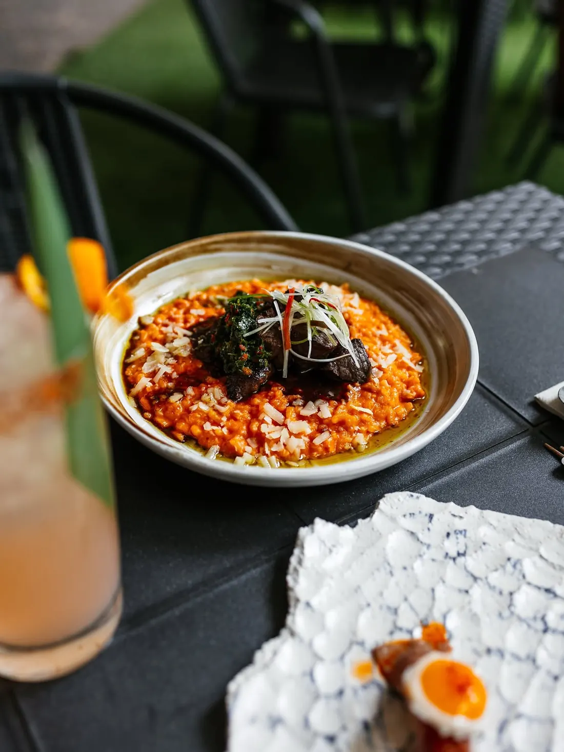 A plate of humi meshi with beef and a cocktail on the table