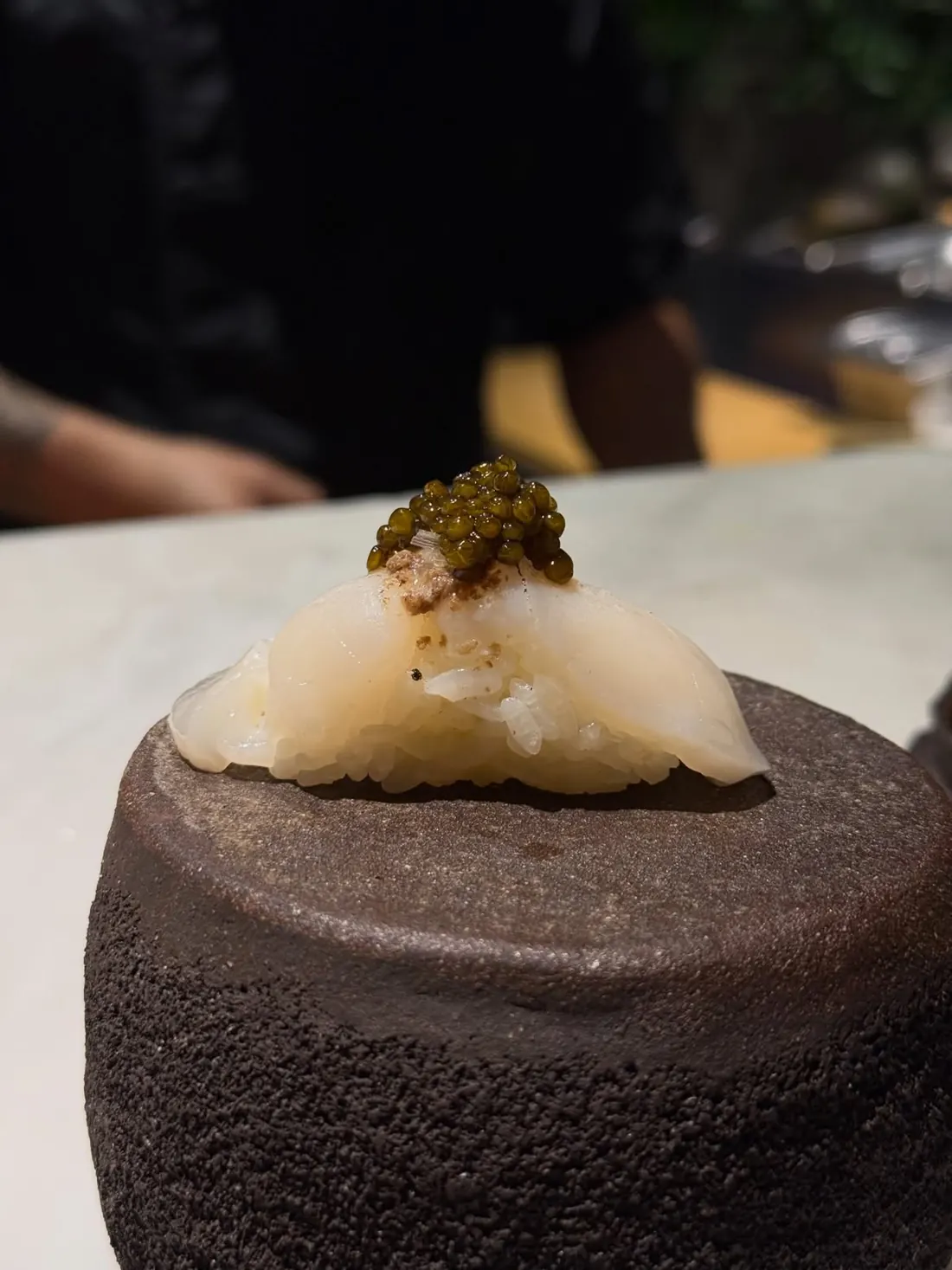 Scallop nigiri with caviar on volcanic stone