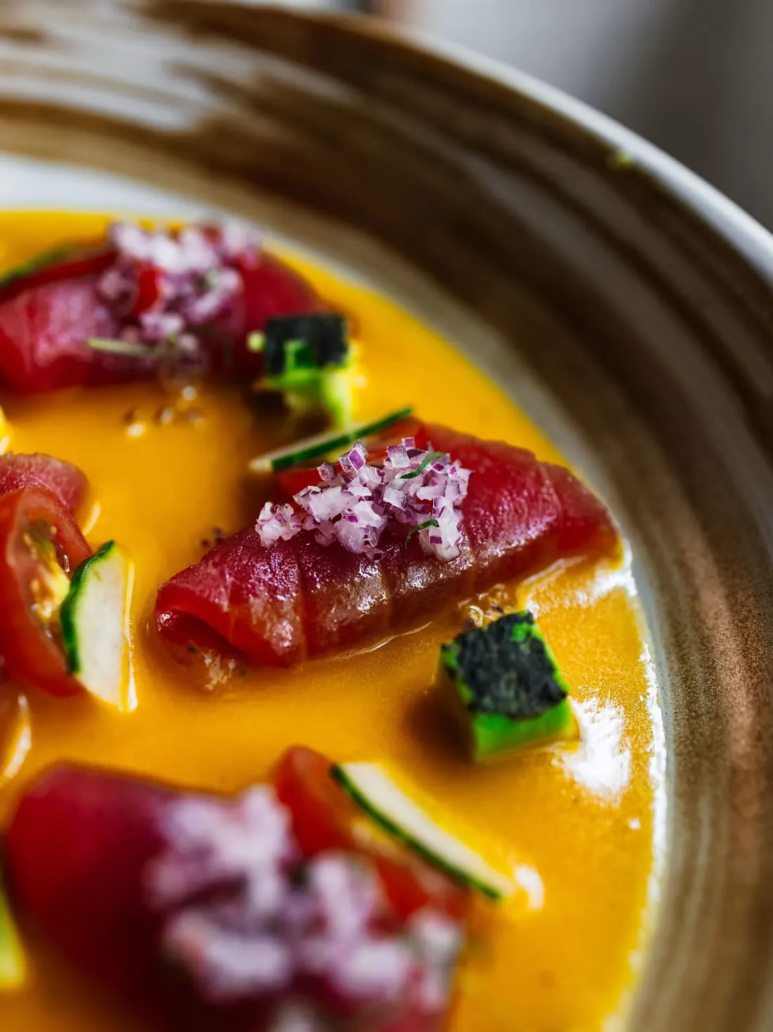 Tuna tiradito in ají amarillo sauce with red onion and cucumber